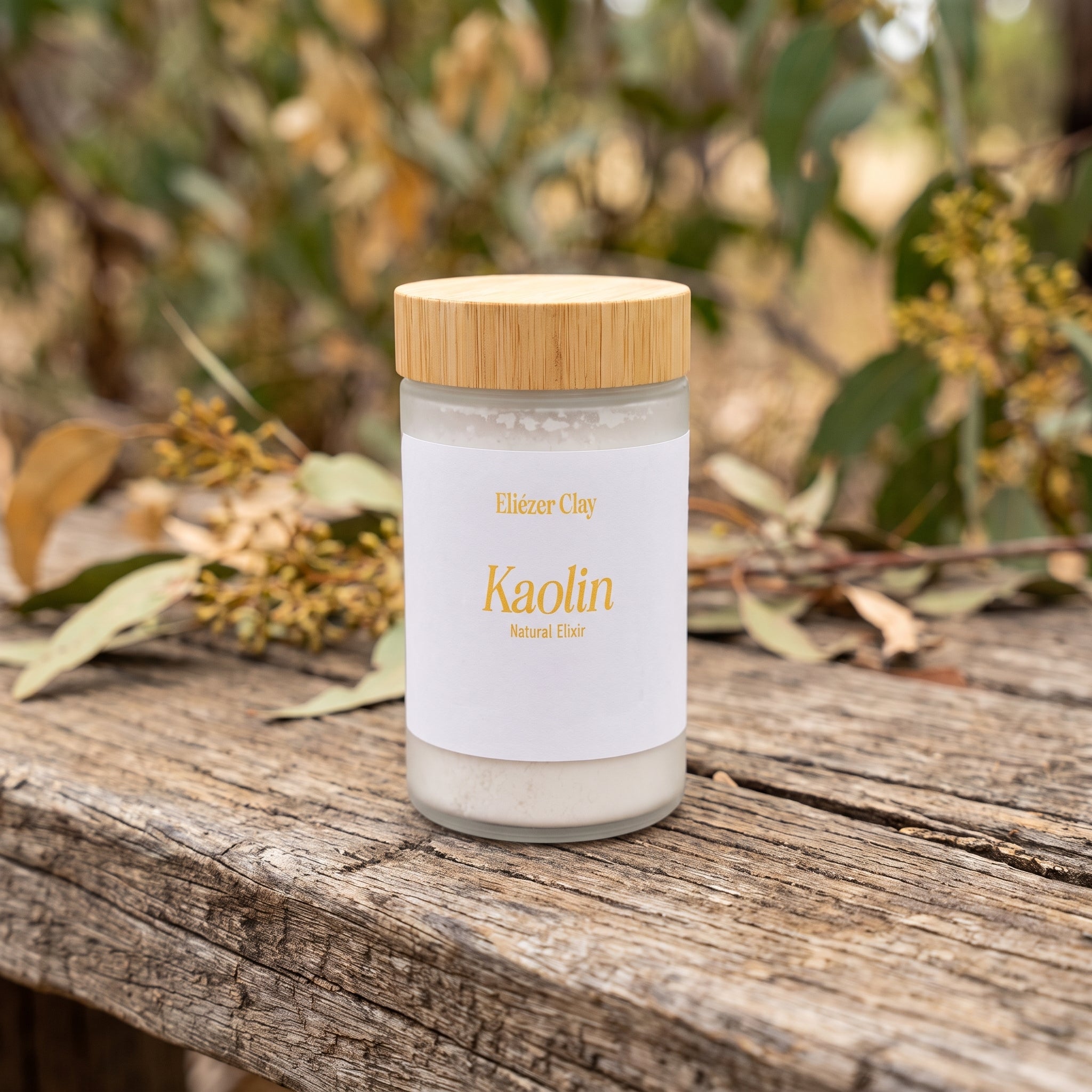 Jar of Eliézer Clay Australian kaolin clay on a rustic timber bench with blurred Australian bushland behind